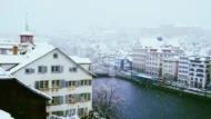 Feiertage Dezember 2026: verschneite Stadt am Fluss im Winter
