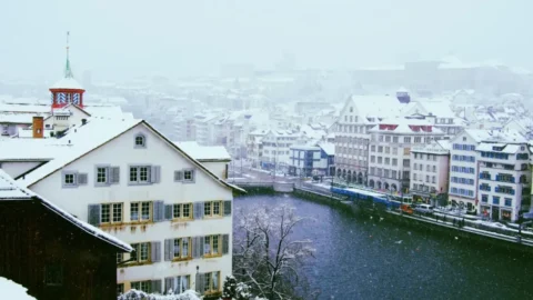Feiertage Dezember 2026: verschneite Stadt am Fluss im Winter